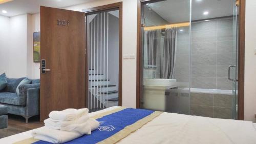 a room with a bed and a shower with towels at Candy Home in Hanoi