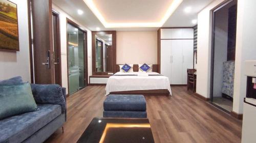 ein Wohnzimmer mit einem Bett und einem Sofa in der Unterkunft Candy Home in Hanoi