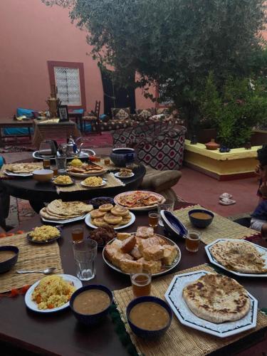 uma mesa com vários tipos diferentes de alimentos em Dar Toda - Zagora guest house em Zagora