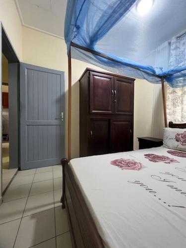 クリビにあるÉvasion Marine à Kribiのベッドルーム1室(青い天蓋付きのベッド1台付)