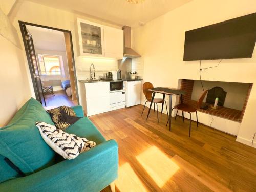 un salon avec un canapé bleu et une cuisine dans l'établissement Le bijou des carmes - Haut de gamme climatisé, à Toulouse