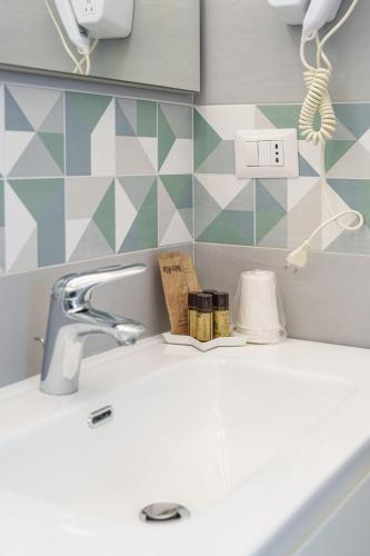 a bathroom sink with a faucet and a book on it at Le Rondinelle Rooms in Procida