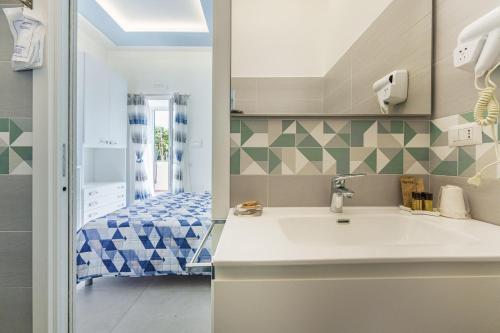 a bathroom with a sink and a bed at Le Rondinelle Rooms in Procida