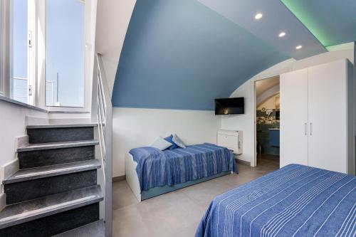 a bedroom with a bed and a staircase in a room at Le Rondinelle Rooms in Procida