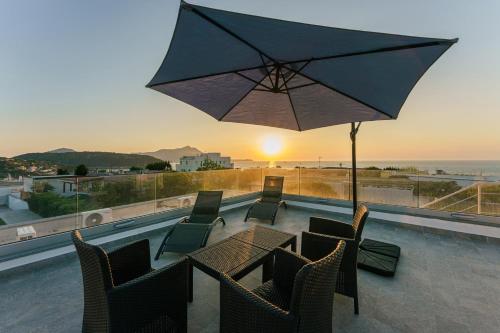 a patio with a table and chairs and an umbrella at Le Rondinelle Rooms in Procida