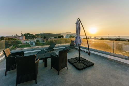 a patio with a table and chairs and an umbrella at Le Rondinelle Rooms in Procida