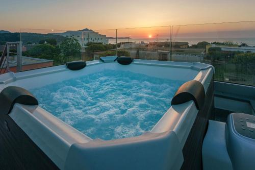 a hot tub on top of a building with the sunset at Le Rondinelle Rooms in Procida