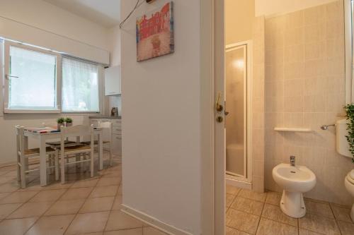 ein Bad mit einem WC und eine Küche mit einem Tisch in der Unterkunft Eolo 1 in Cervia