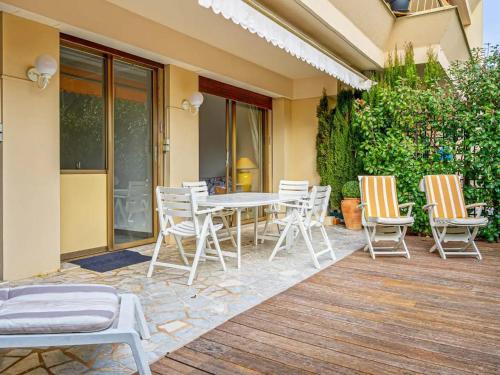 un patio avec une table et des chaises sur une terrasse dans l'établissement Résidence Fleurie One Bedroom Apartment, à Cannes