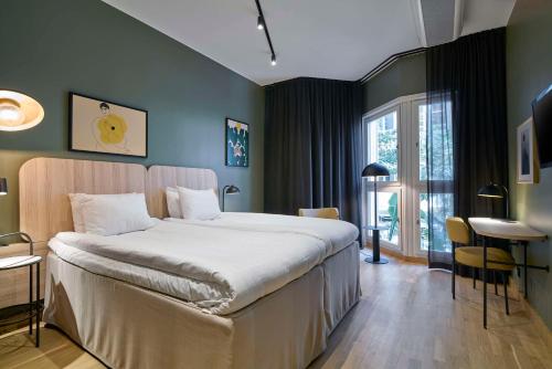 謝萊夫特奧的住宿－斯堪謝萊夫特奧酒店，一间卧室配有一张大床和一张桌子