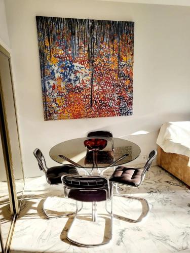 une table et des chaises dans une pièce avec un tableau dans l'établissement Résidence Fleurie One Bedroom Apartment, à Cannes