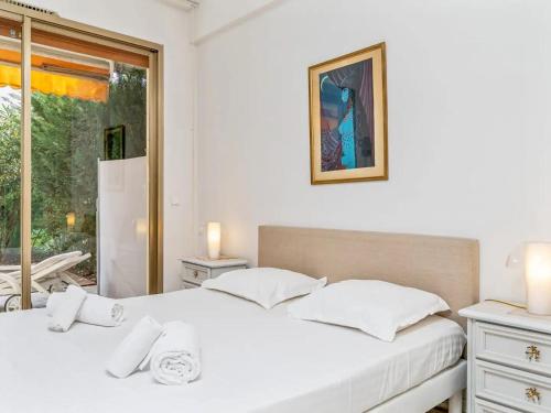 - 2 lits blancs dans une chambre avec fenêtre dans l'établissement Résidence Fleurie One Bedroom Apartment, à Cannes