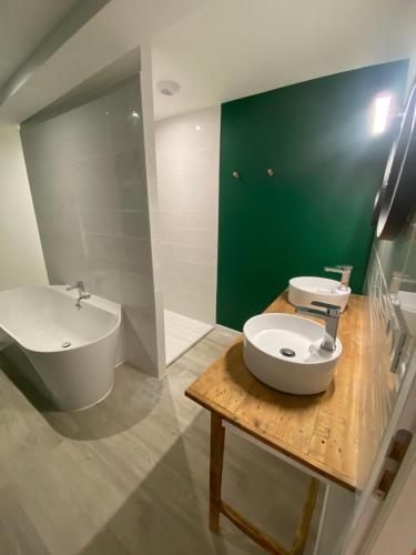 a bathroom with a sink and a toilet and a tub at Le gîte du bonheur in Dalou