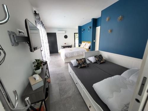 Habitación pequeña con 2 camas y TV. en Le Mas De Poujoles en Caussade