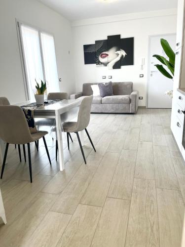 a living room with a table and chairs and a couch at MaurusHome come a casa tua. in Fiumicino