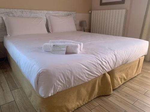 a large white bed with towels on top of it at La Bergamina Hotel & Restaurant in Arcore