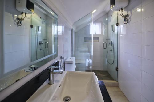 uma casa de banho com um lavatório, um espelho e um WC. em Hamasville Boutique Hotel em Abuja