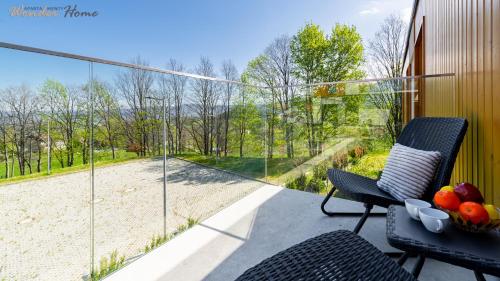 a patio with two chairs and a bowl of fruit at Wonder Home - Domki Hillside tuż przy stoku narciarskim - na terenie kompleksu plac zabaw i zewnętrzna siłownia, sklep, parking in Karpacz