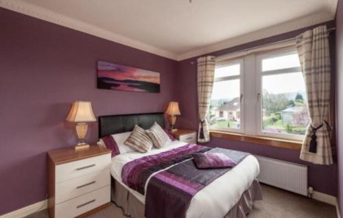 Dormitorio púrpura con cama y ventana en Hillhouse Blackhall en Edimburgo