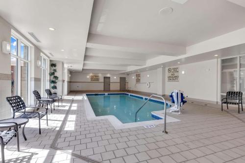 a pool in the middle of a room with chairs at Hilton Garden Inn Myrtle Beach/Coastal Grand Mall in Myrtle Beach