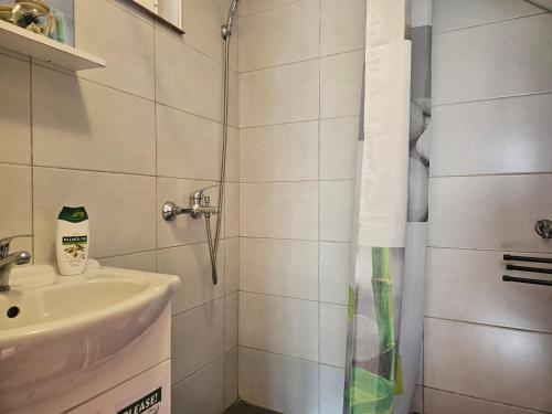a small bathroom with a sink and a shower at Apartman Sara-Vis in Vis