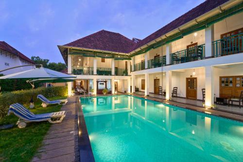 una imagen de una casa con piscina en Napier Heritage, en Kochi
