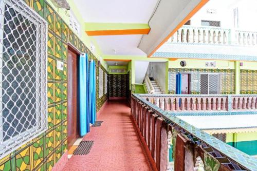 een lege gang van een gebouw met kleurrijke tegels bij Goroomgo Sri Ram Guest House Puri in Puri