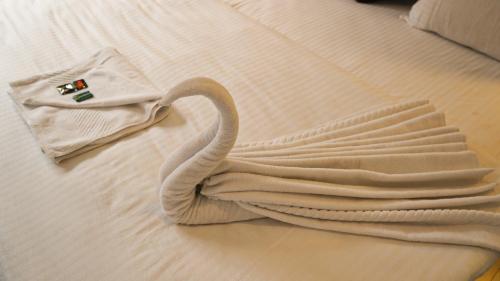 a swan laying on a bed with a towel at Hotel Sherabling in Gangtok