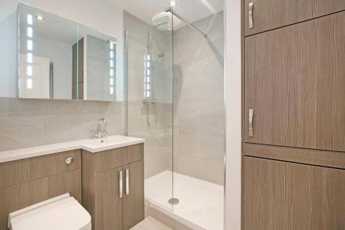 a bathroom with a shower and a toilet and a sink at Bright & Spacious Central Apartment in Harrogate