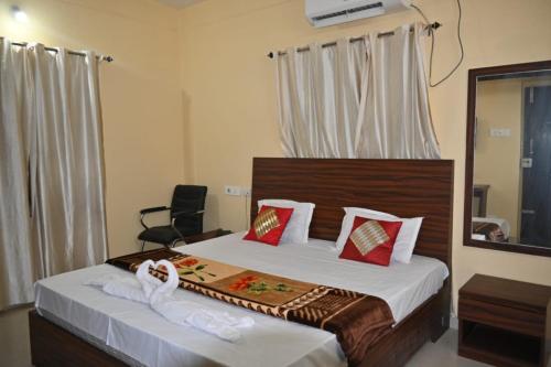 a bedroom with a bed and a chair and a mirror at Goroomgo Green Akress Bhubaneswar in Bhubaneshwar