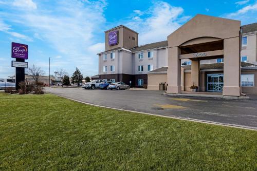 a building with a car parked in front of it at Sleep Inn & Suites Green Bay South in De Pere