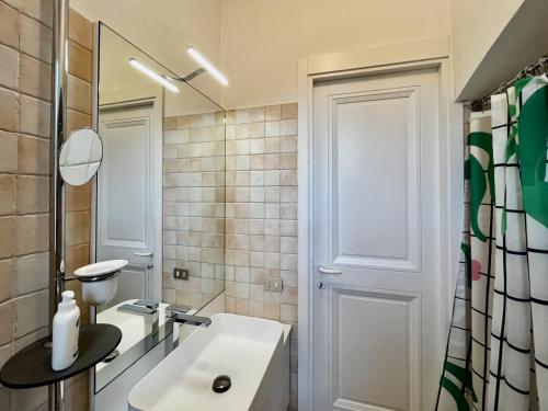 uma casa de banho branca com um lavatório e um espelho em Country house close to Orta Lake em Bolzano Novarese