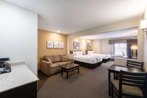 a hotel room with a bed and a couch at Sleep Inn & Suites Green Bay South in De Pere