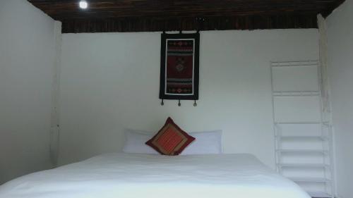 ein Schlafzimmer mit einem weißen Bett und einem Schild an der Wand in der Unterkunft MUONG HOA Peaceful HOMESTAY & Sapa in Lào Cai