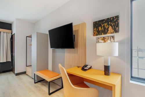a hotel room with a desk and a tv on the wall at Comfort Suites Cheyenne in Cheyenne