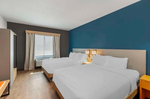 a hotel room with two beds and a blue wall at Comfort Suites Cheyenne in Cheyenne