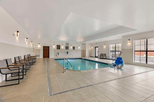 Comfort Suites Cheyenne في شايان: مسبح كبير في مبنى فيه كراسي