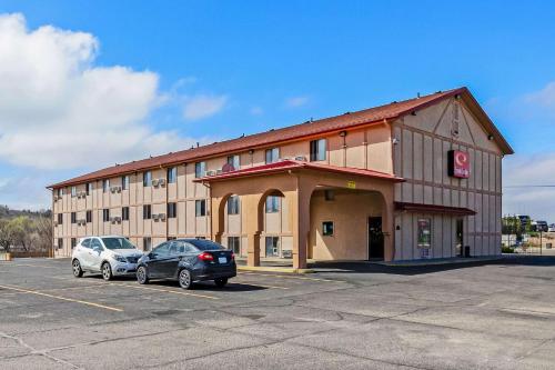 um grande edifício com dois carros estacionados num parque de estacionamento em Econo Lodge Junction City I-70 Near Fort Riley em Junction City