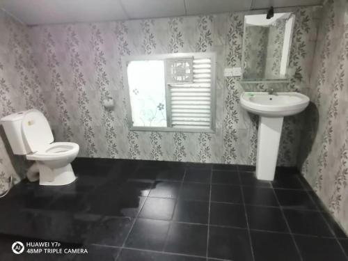 y baño con aseo y lavamanos. en Walawwa resort en Kurunegala