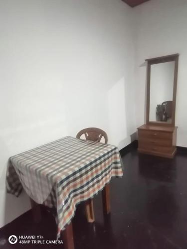 uma mesa com uma toalha de mesa xadrez e um espelho em Walawwa resort em Kurunegala