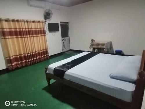 um quarto com uma cama e um piso verde em Walawwa resort em Kurunegala