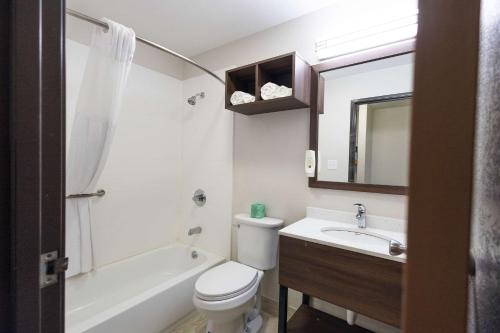 a bathroom with a toilet and a sink and a bath tub at Quality Inn in Carrollton