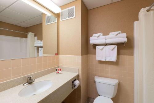 a bathroom with a sink and a toilet and a mirror at Travelodge by Wyndham Deadwood in Deadwood