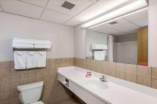 a bathroom with a sink and a toilet and a mirror at Travelodge by Wyndham Deadwood in Deadwood