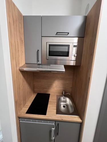 a kitchen with a microwave and a sink at Firstsleep Ebersberg in Ebersberg