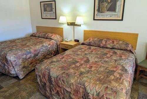 a hotel room with two beds and a telephone at Travelodge by Wyndham Deadwood in Deadwood