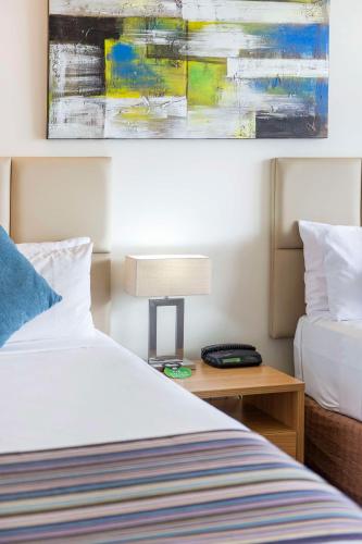 a hotel room with a bed and a table with a lamp at Rydges Esplanade Resort Cairns in Cairns