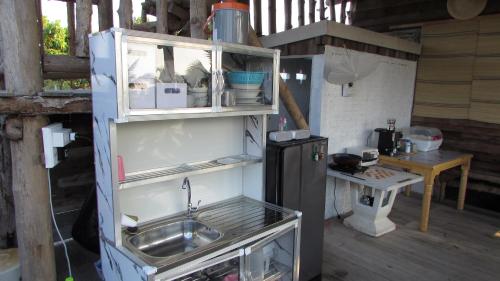 a kitchen with a sink and a refrigerator at Villa De Lumhun in Lamphun