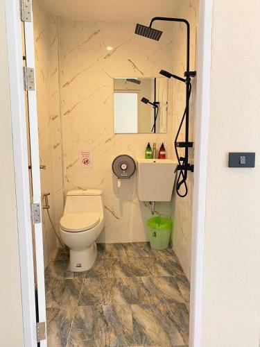 a bathroom with a toilet and a sink and a mirror at Flora Hostel KhaoSok in Khao Sok