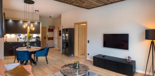 a living room with a table and chairs and a tv at Residenz Illyrica Tirol in Westendorf